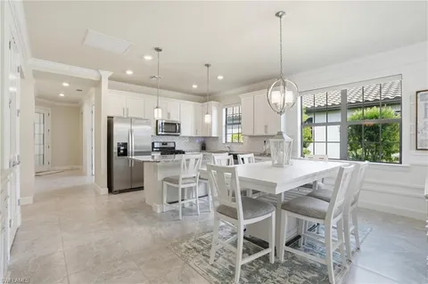 a kitchen with kitchen island granite countertop a counter space dining table and stainless steel appliances