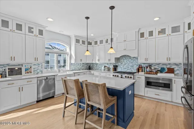 a kitchen with kitchen island granite countertop a sink counter top space appliances and cabinets