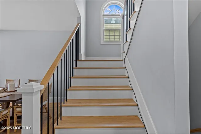 a view of staircase with wooden floor and a front door