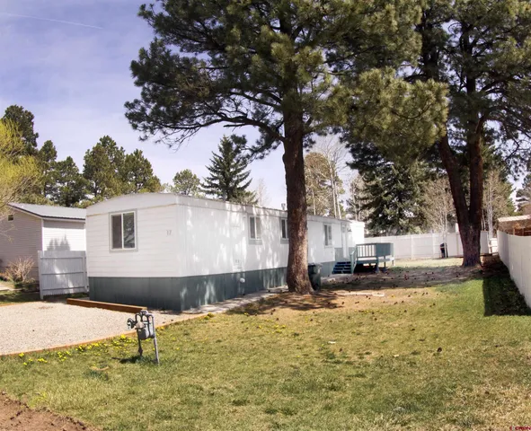 a front view of a house with a yard and tree s