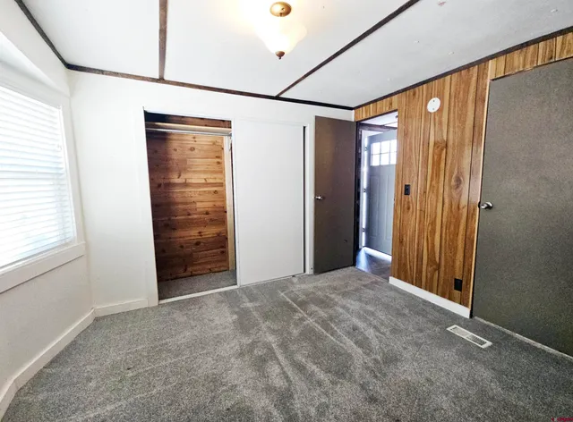 an empty room with closet and a window