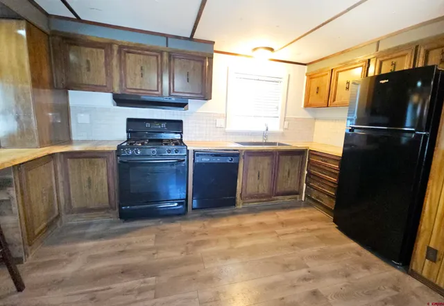 a kitchen with stainless steel appliances granite countertop a refrigerator and a stove