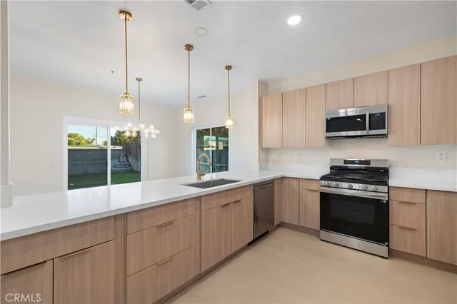 a kitchen with stainless steel appliances granite countertop a stove a sink and a microwave
