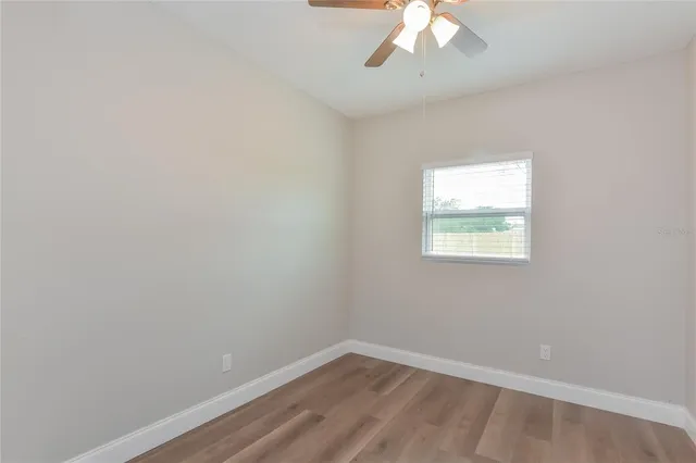 an empty room with a chandelier fan