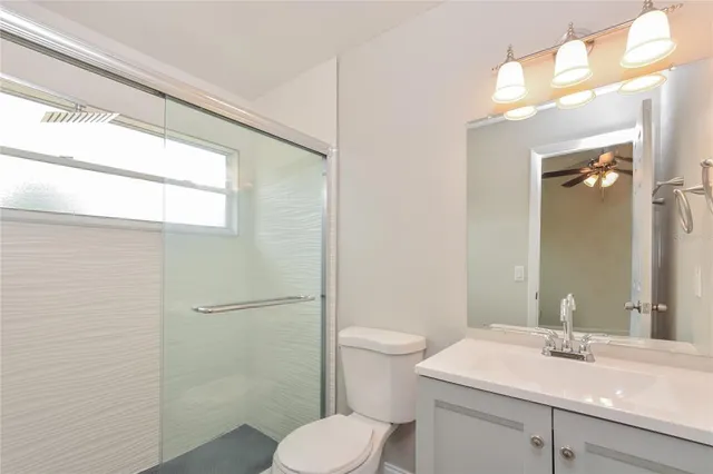 a bathroom with a sink toilet vanity and shower