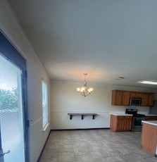 14909 Nuttall Drive Austin, TX 78724 - Photo 5 of 13 Kitchen featuring hanging lights, wood finish cabinets, stainless steel appliances, and light countertops