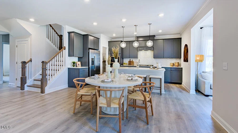 229 Tidal Pool Way Cary, NC 27519 - Photo 11 of 32 a kitchen with stainless steel appliances kitchen island granite countertop a table chairs and a refrigerator