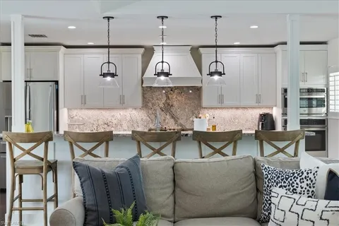 a living room with kitchen island furniture and a chandelier