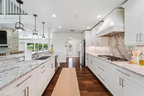 a large kitchen with stainless steel appliances kitchen island granite countertop a sink and cabinets
