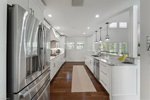 a large kitchen with stainless steel appliances kitchen island a large counter top a stove and a refrigerator