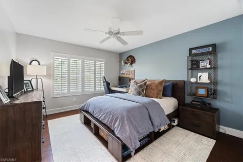 a spacious bedroom with a bed a couch and a flat tv screen on a dresser