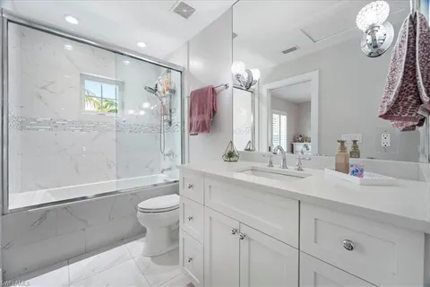 a bathroom with a double vanity sink toilet mirror and shower