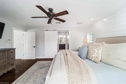 a bedroom with a large bed and a chandelier