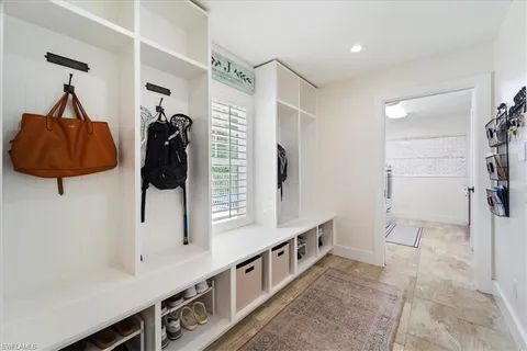 a hallway with white cabinets and window