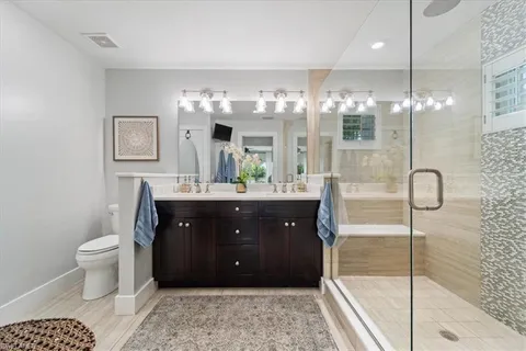 a bathroom with a sink a toilet and shower