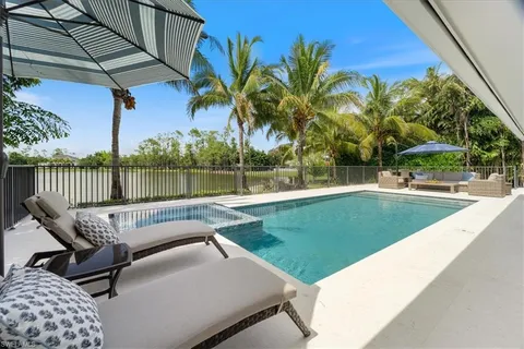 a view of a swimming pool with a patio and a yard