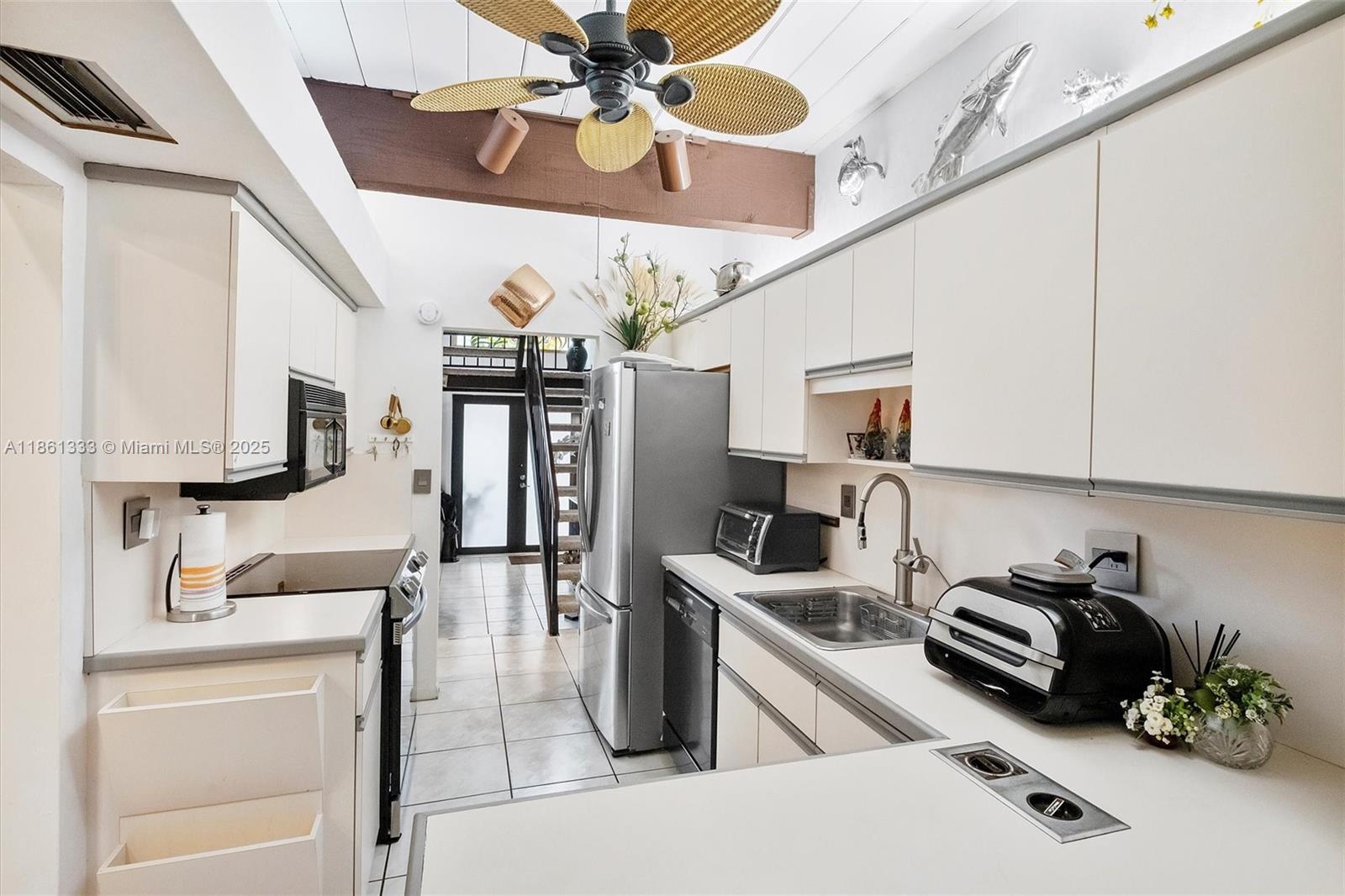 10409 Southwest 80th Street Miami, FL 33173 - Photo 21 of 35 a kitchen with stainless steel appliances granite countertop a sink dishwasher stove and refrigerator with wooden floor