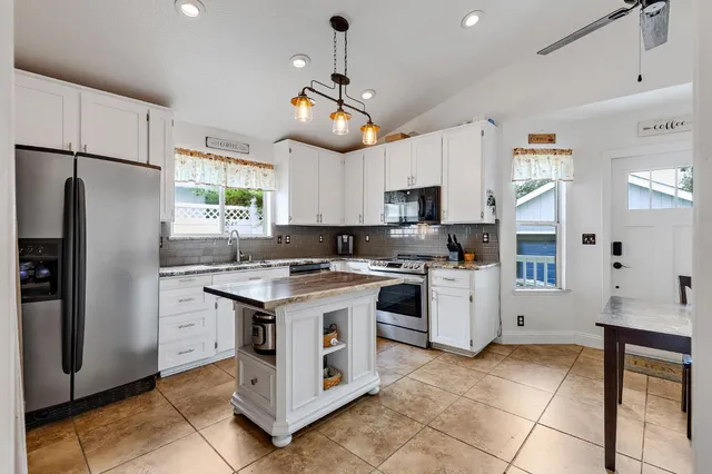 a kitchen with stainless steel appliances granite countertop a stove a refrigerator and a refrigerator
