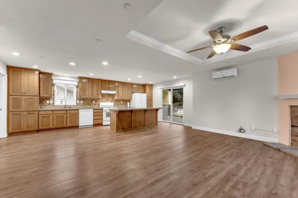 a view of empty room with wooden floor and fireplace