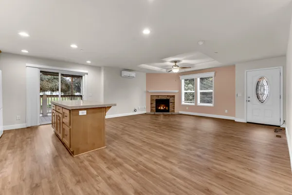 a kitchen with stainless steel appliances granite countertop a stove a sink dishwasher a refrigerator and white cabinets with wooden floor