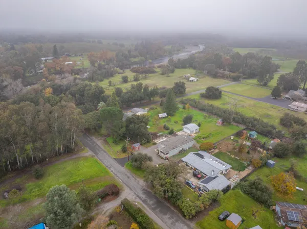 a backyard of a house with lots of green space and fountain in the back