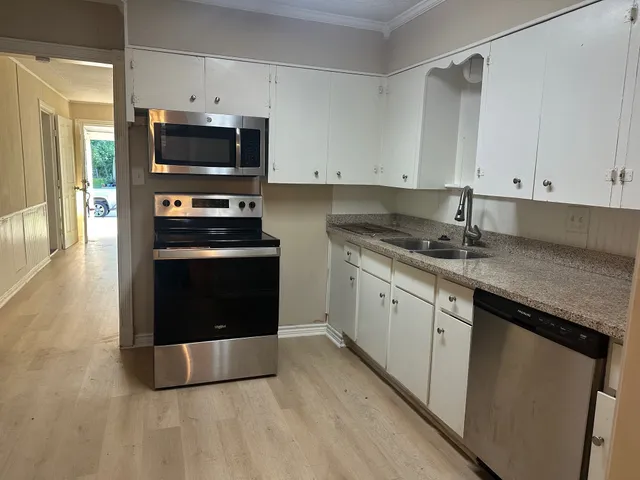 a kitchen with stainless steel appliances granite countertop a stove a sink and a microwave