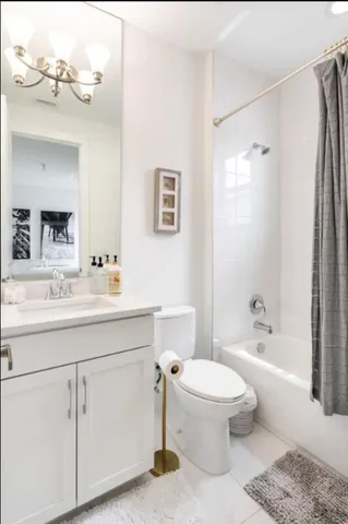 a bathroom with a toilet a sink a mirror a bathtub and vanity