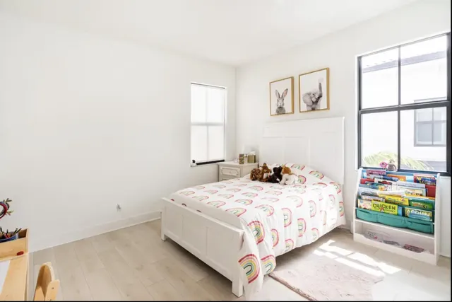 a bedroom with a bed and painting on the wall