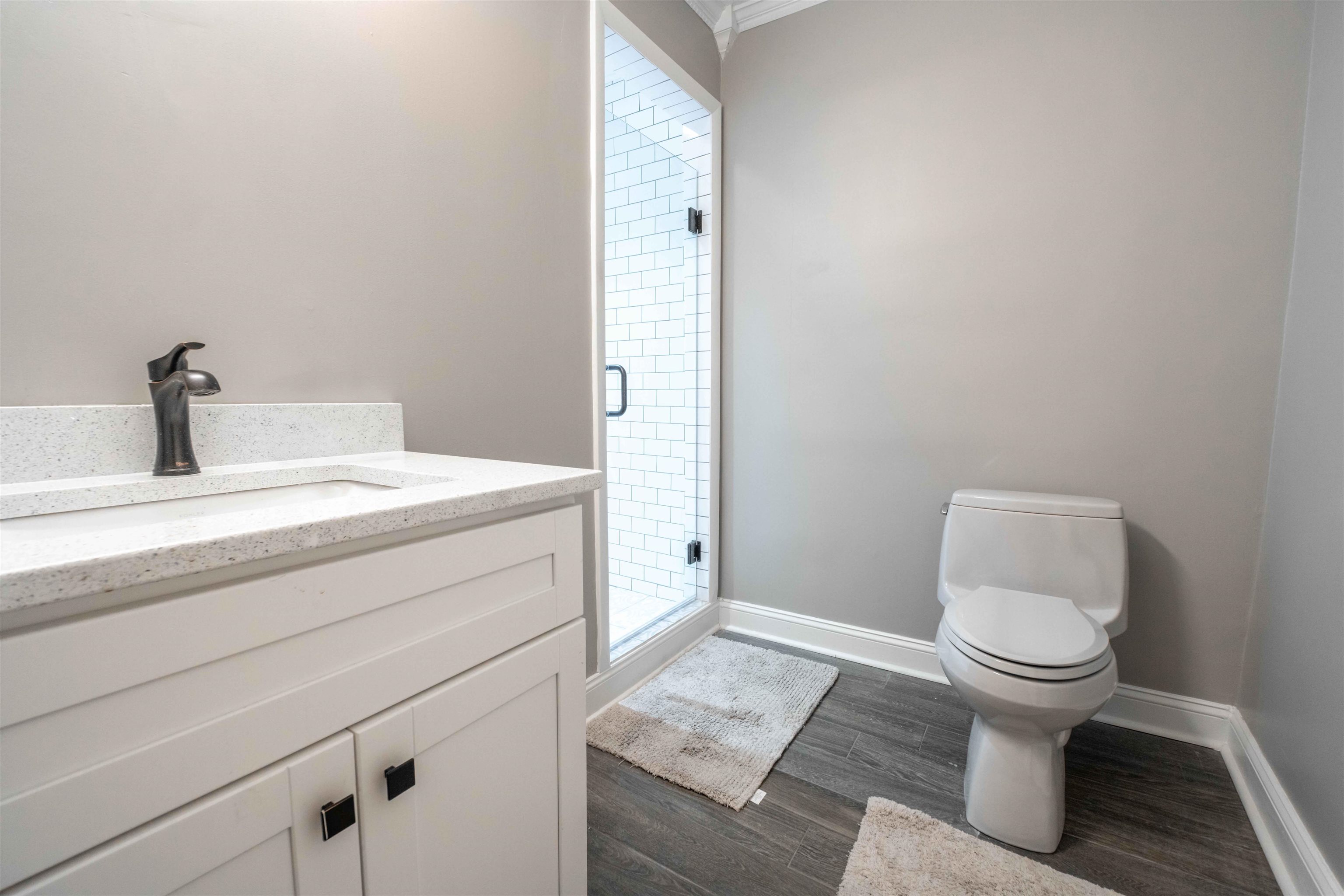 1239 Whitten Road Memphis, TN 38134 - Photo 18 of 24 Full bathroom with vanity, dark wood-style flooring, a stall shower, and crown molding