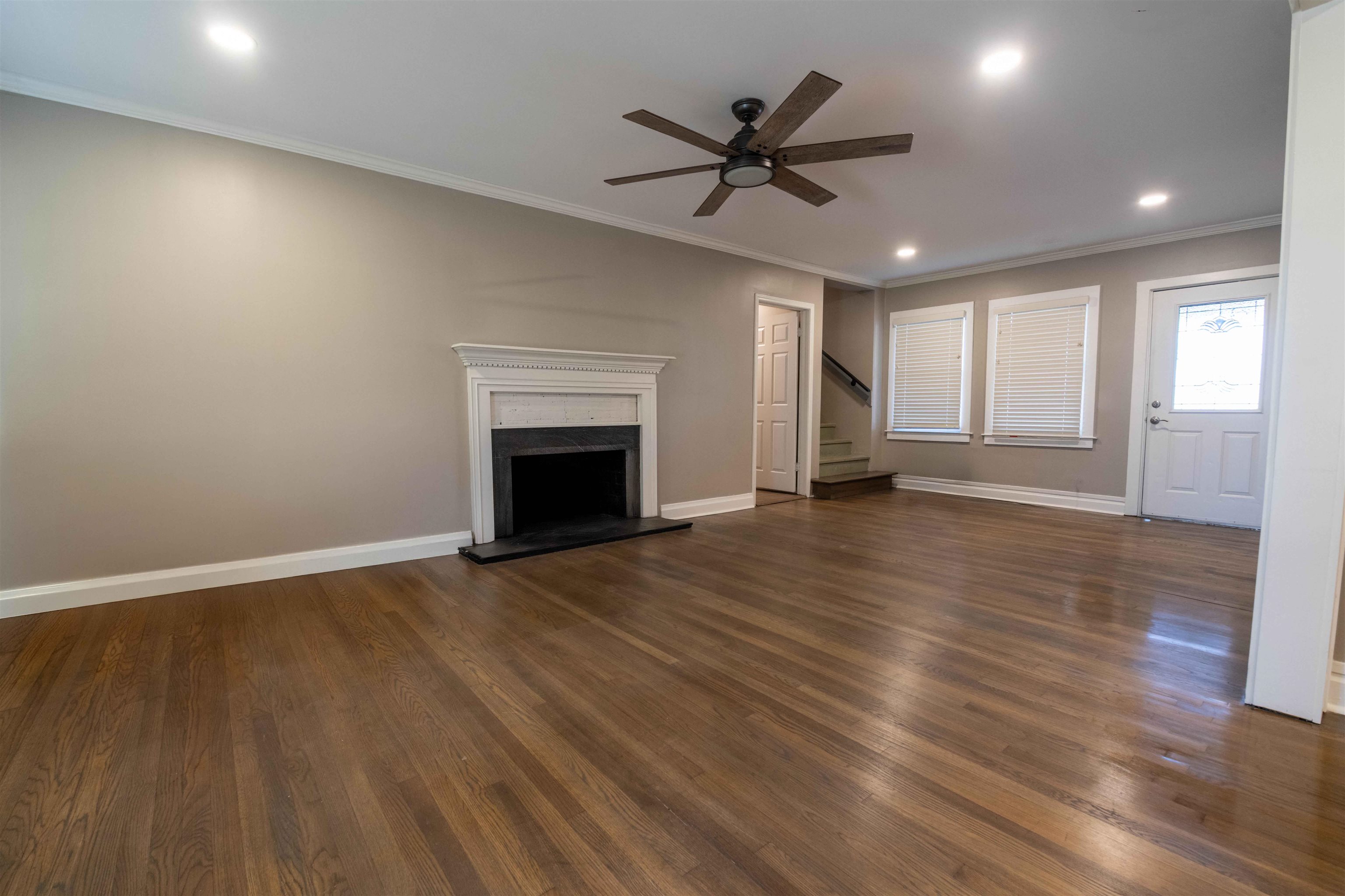 1239 Whitten Road Memphis, TN 38134 - Photo 8 of 24 Unfurnished living room with recessed lighting, ornamental molding, dark wood finished floors, a high end fireplace, and stairs