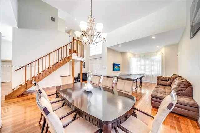 a view of a dining room with furniture a chandelier and wooden floor