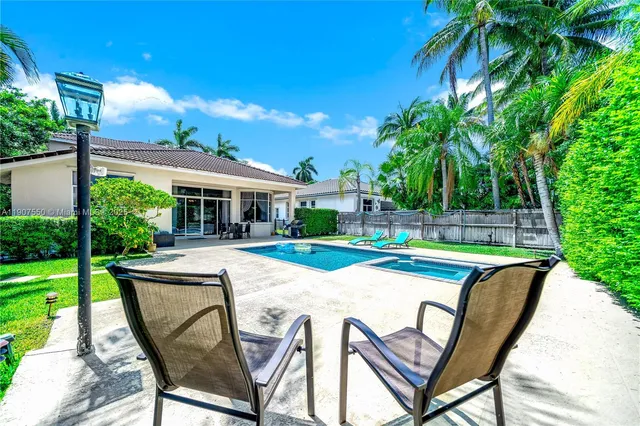 a view of a house with pool and chairs