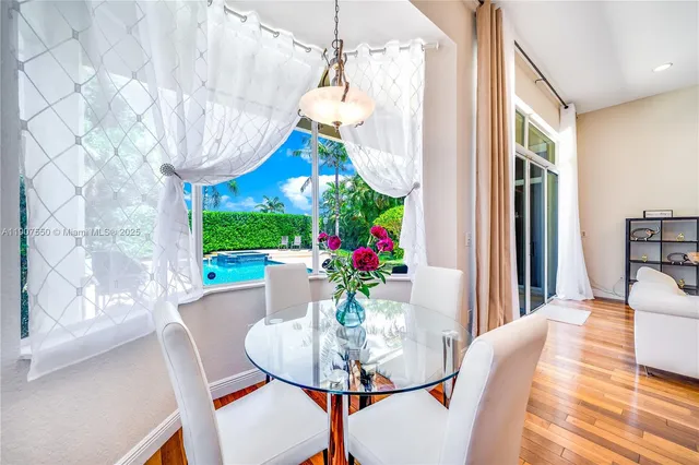a view of a dining room with furniture a chandelier and wooden floor