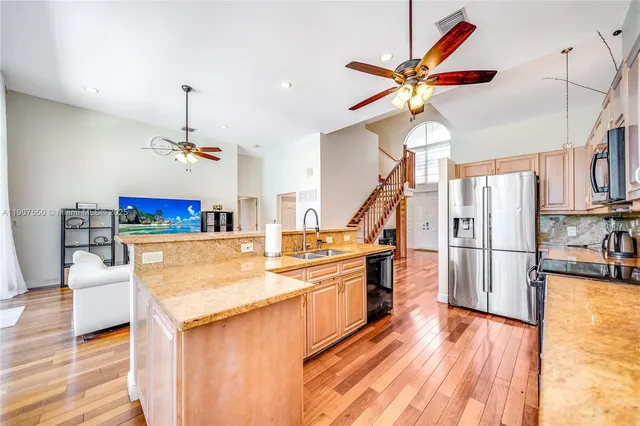 a view of a kitchen with sink and wooden floor
