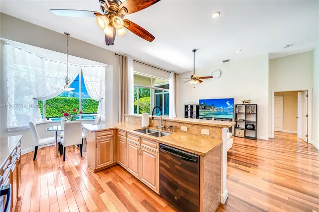 a kitchen with stainless steel appliances granite countertop a stove and a wooden floors