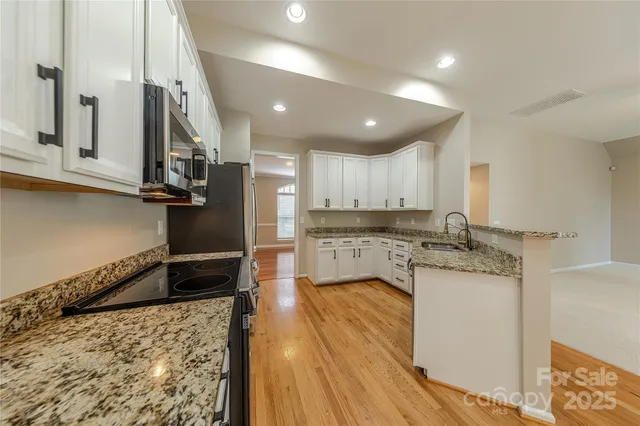 a kitchen with stainless steel appliances granite countertop a sink refrigerator and cabinets