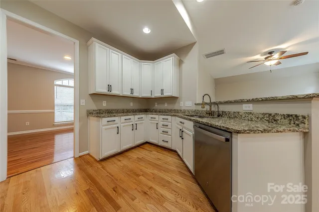 a kitchen with granite countertop a stove top oven sink and cabinets