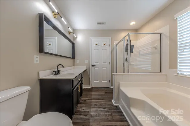 a bathroom with a bathtub sink mirror vanity and toilet