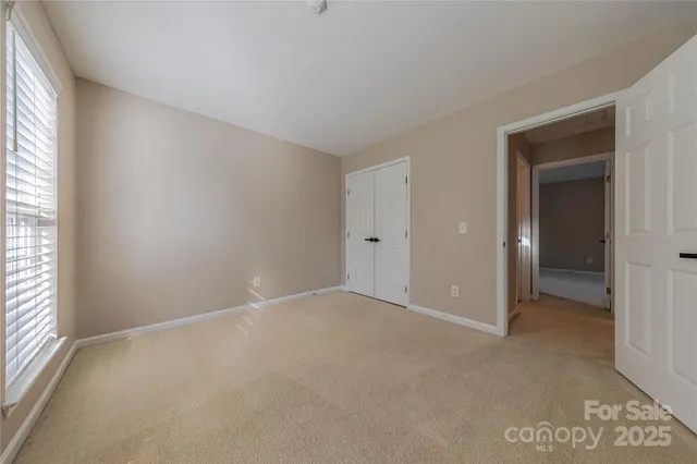 an empty room with windows and closet