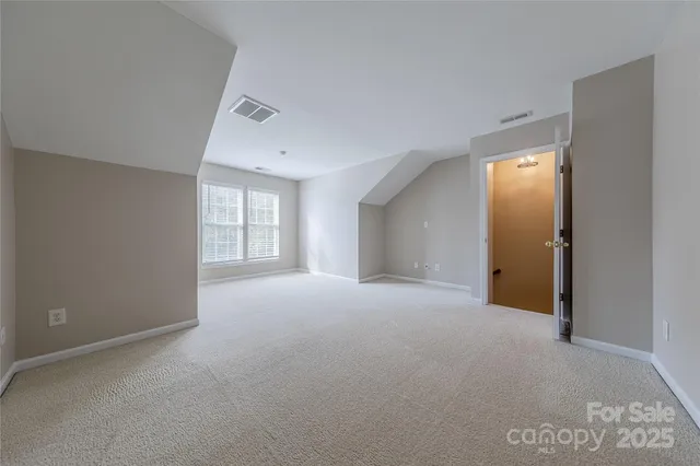 a view of an empty room with windows and closet