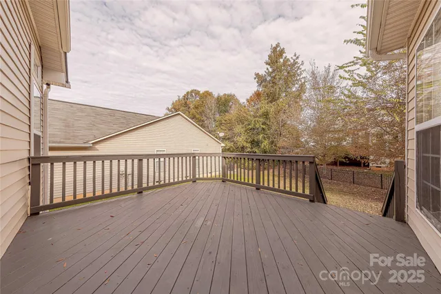 a view of a balcony with wooden floor and fence