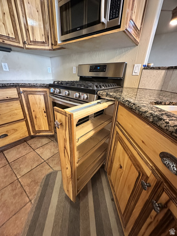 140 North 200 E Street Glenwood, UT 84730 - Photo 10 of 54 Kitchen with dark stone counters, stainless steel appliances, dark tile patterned floors, and wood finish cabinetry