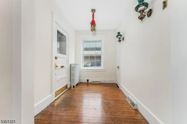 a view of a hallway with wooden floor and a window