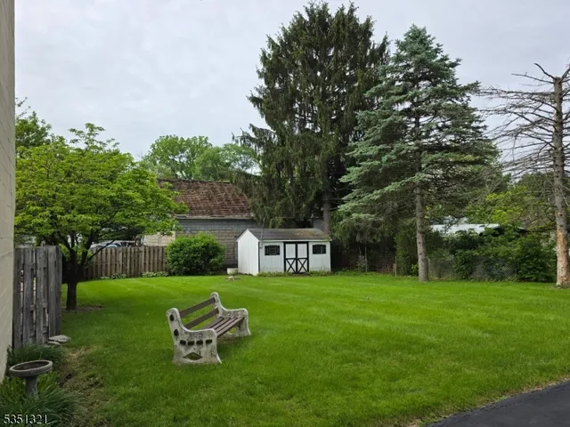 a view of a yard with wooden fence