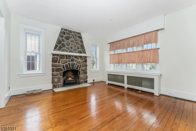an empty room with fireplace and wooden floor