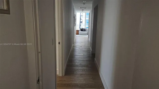 a view of a hallway with wooden floor