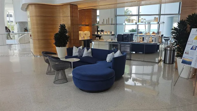 a dining room with furniture and a floor to ceiling window