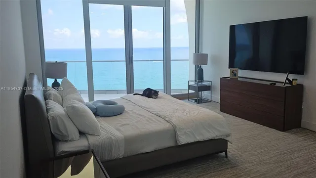 a bedroom with a bed window and a television