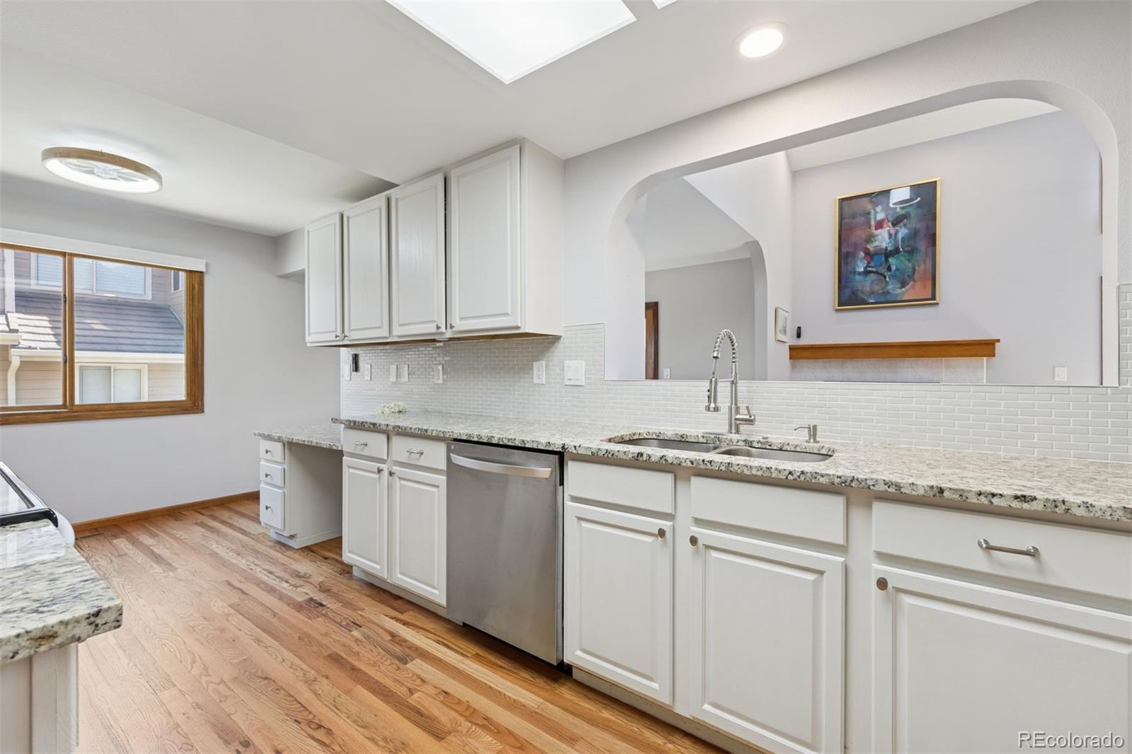 23860 Genesee Village Road Golden, CO 80401 - Photo 13 of 36 a kitchen with granite countertop cabinets stainless steel appliances wooden floor and a window