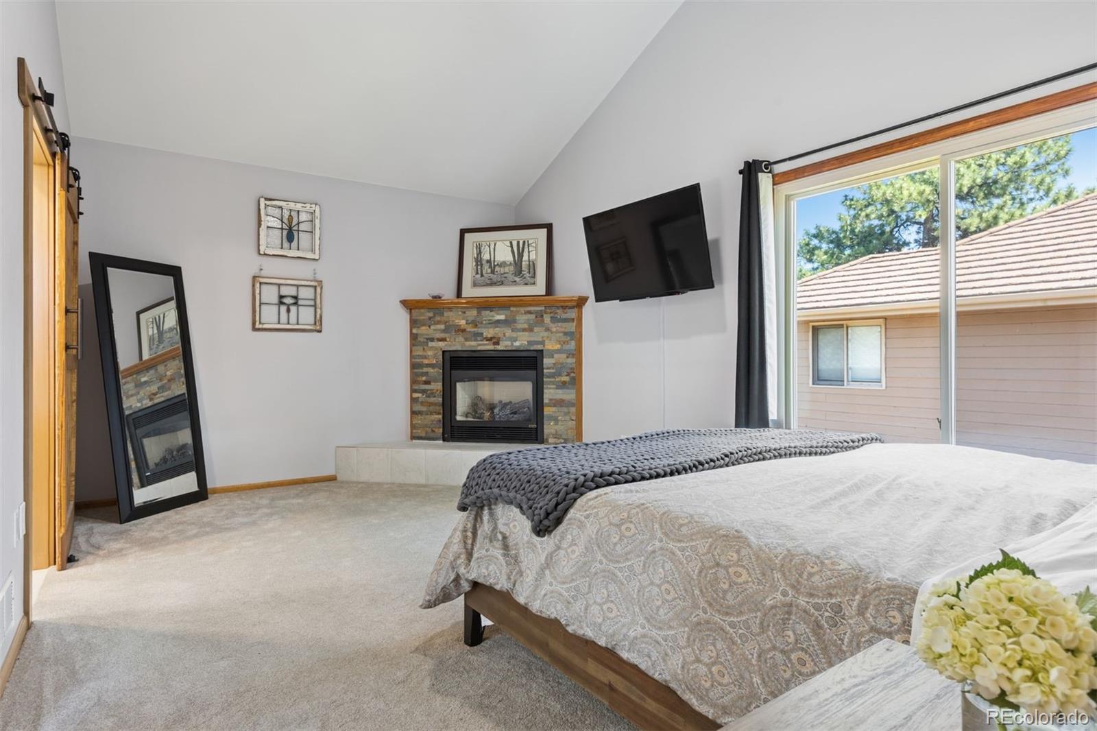 23860 Genesee Village Road Golden, CO 80401 - Photo 16 of 36 a bedroom with a bed and a fireplace